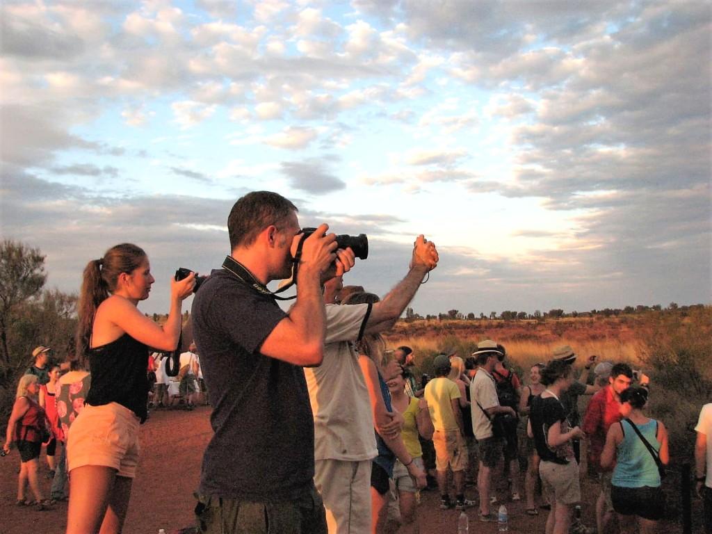 ludzie fotografujący barwy Uluru o wschodzie słońca Australia