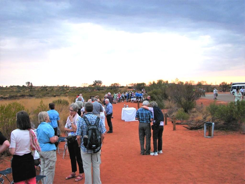 ludzie podziwiający Uluru o zachodzie słońca Australia